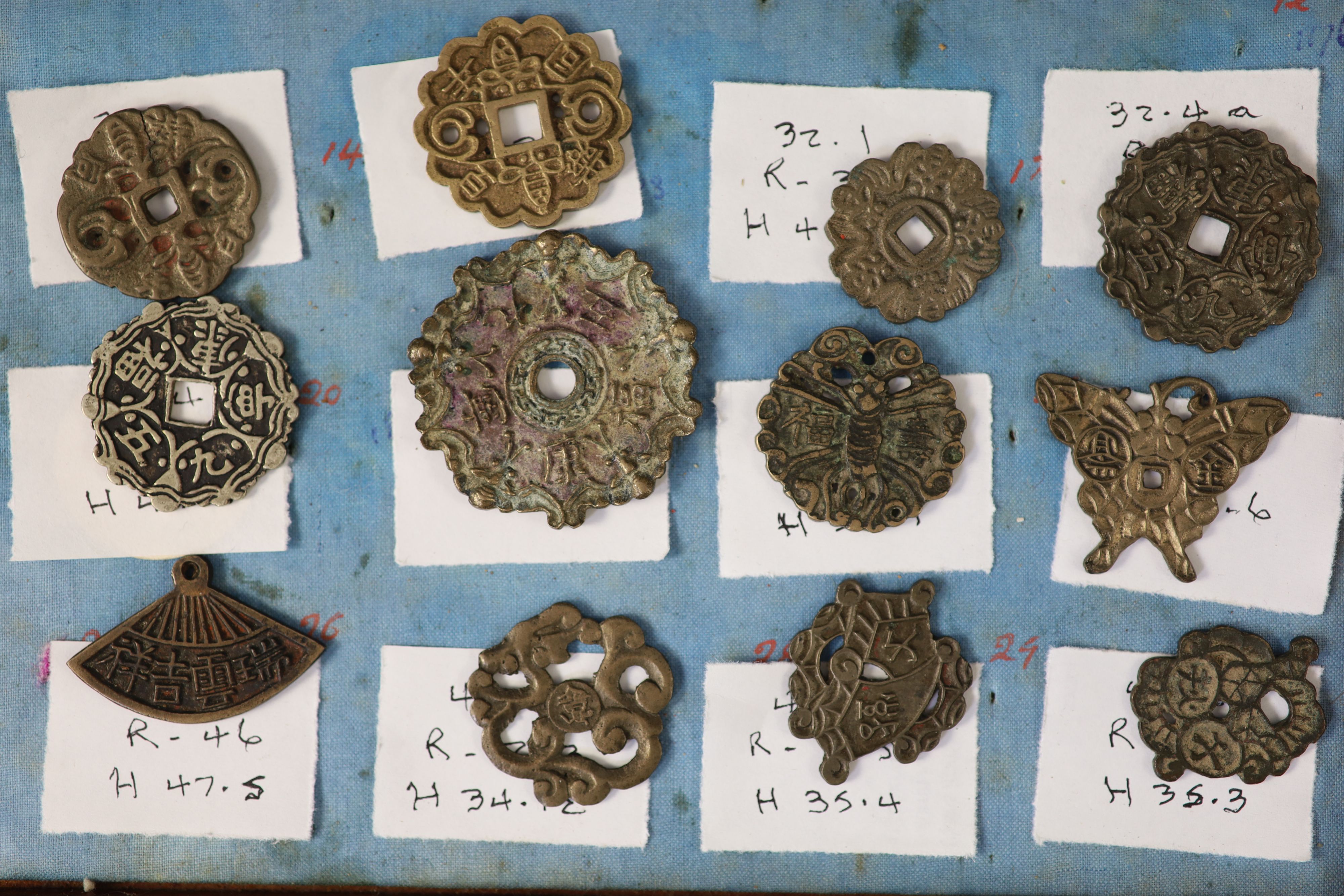 A group of 99 Korean bronze and metal amulets or charms, 19th/20th century